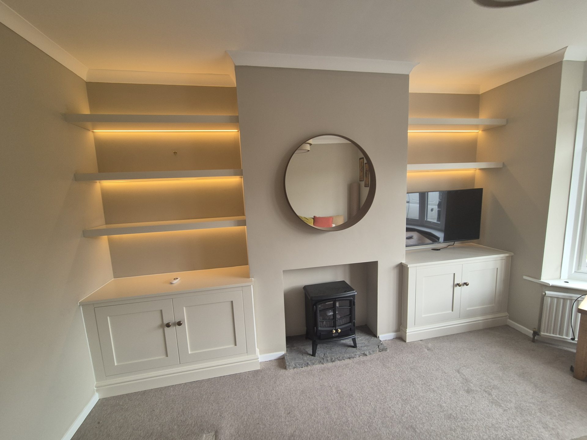 Illuminated floating shelves in fitted alcoves