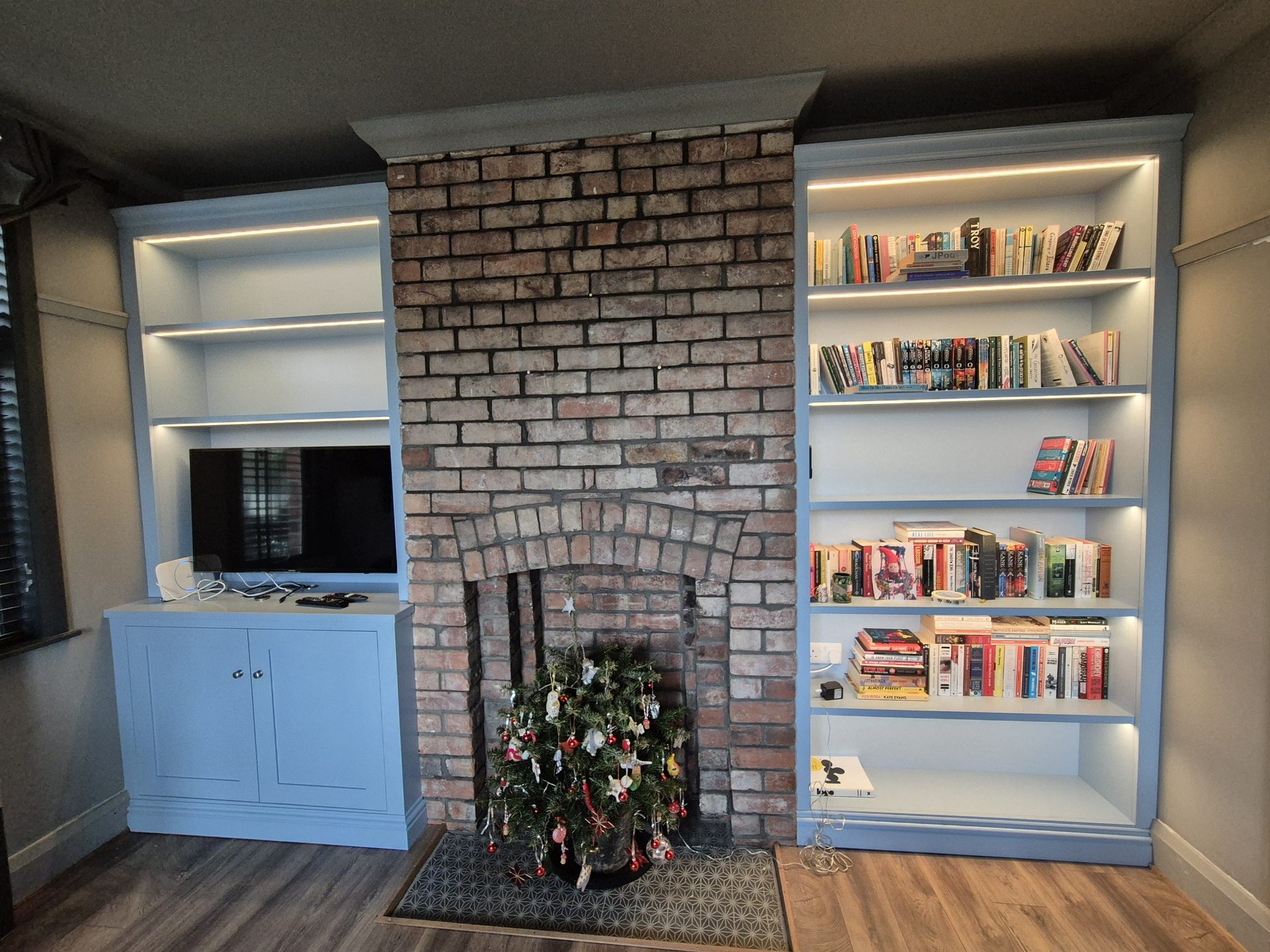 Alcove cabinets and shelving around an exposed brick fireplace