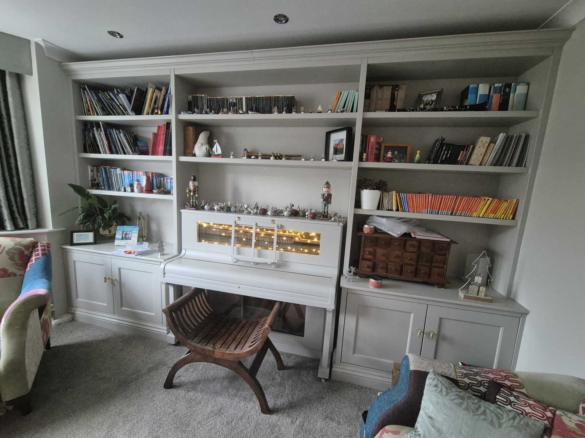 Full-width grey bookcase wall with a reading chair