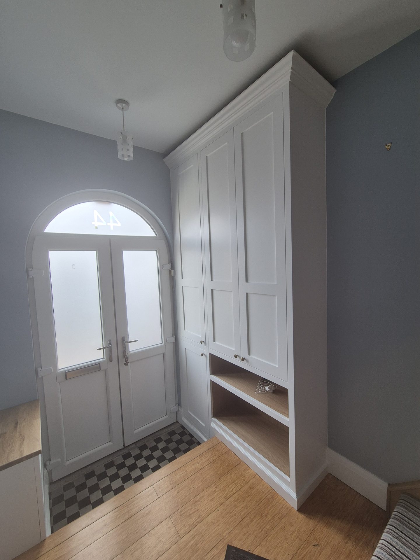 White fitted wardrobe beside an arched doorway