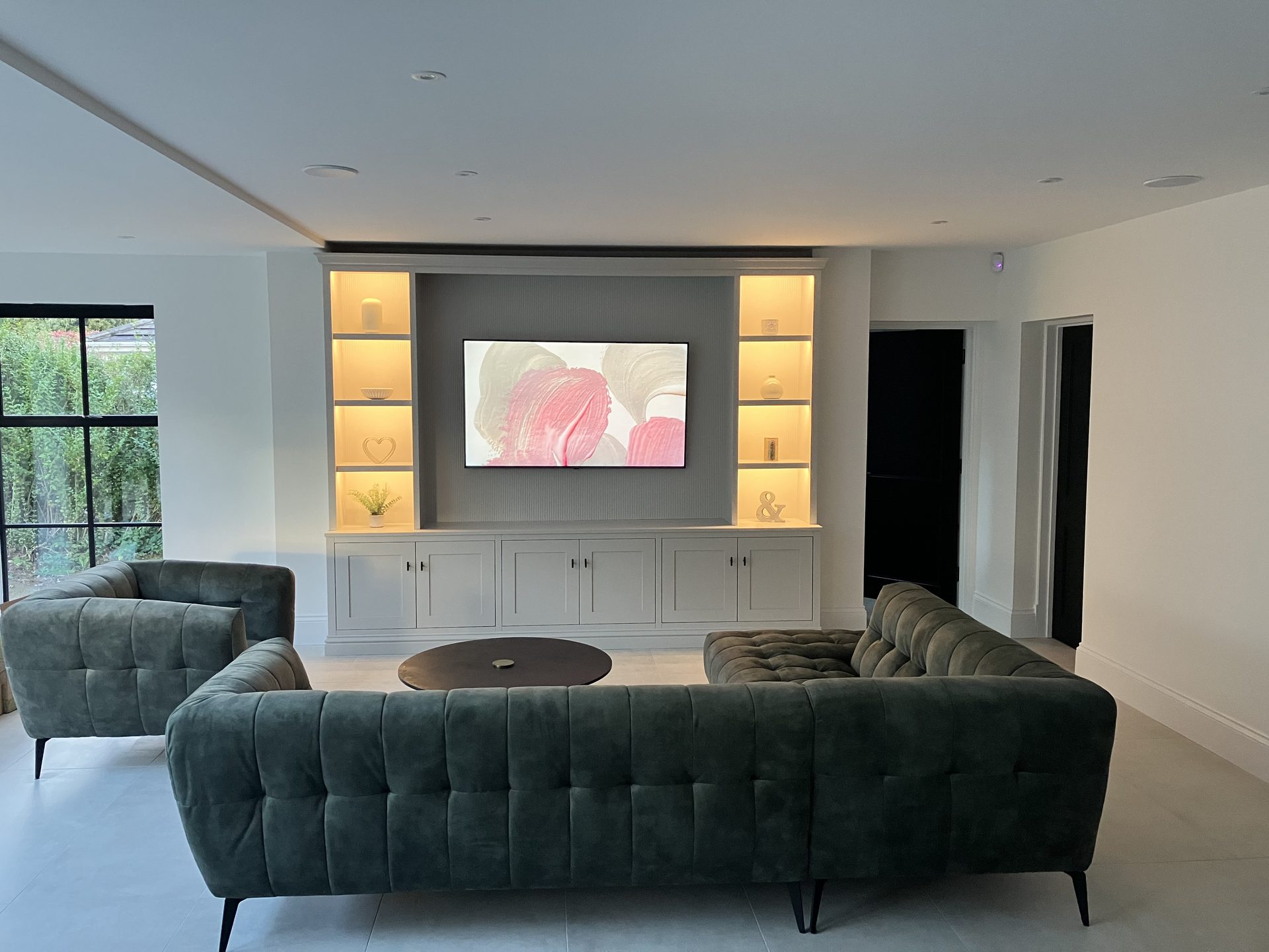 Media wall with television and illuminated display niches
